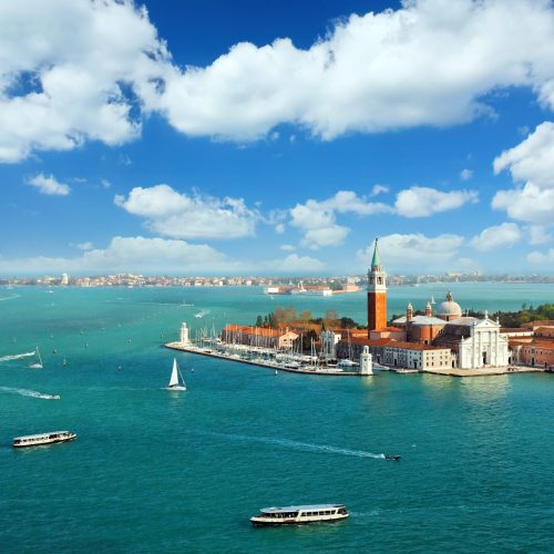 Aerial view of the lagoon of Venice and San Giorgio Maggiore. Heavy ship traffic, lovely clouds on the blue sky.